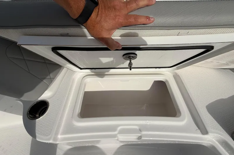 Slide: The Image of 2026 Blazer Bay Makaira 2600 boat storage compartment with open lid and cup holder. - 36