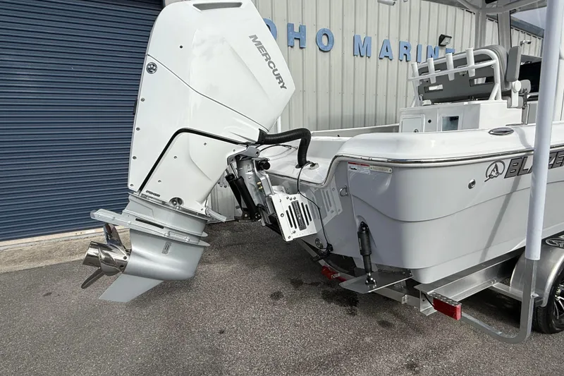 Slide: The Image of 2026 Blazer Bay Makaira 2600 boat with Mercury outboard motor, parked at a marina. - 7
