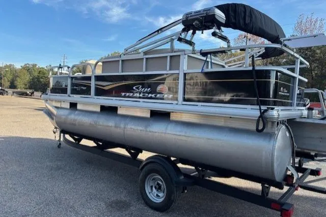Slide: The Image of 2021 Sun Tracker Bass Buggy 18 DLX pontoon boat on trailer in outdoor setting. - 57