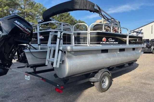 Slide: The Image of 2021 Sun Tracker Bass Buggy 18 DLX pontoon boat on trailer, featuring Mercury outboard motor. - 60