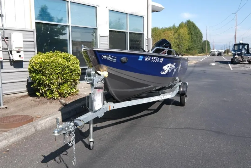 Slide: The Image of 2024 Crestliner 1650 Discovery Tiller boat on trailer, parked outdoors. - 3