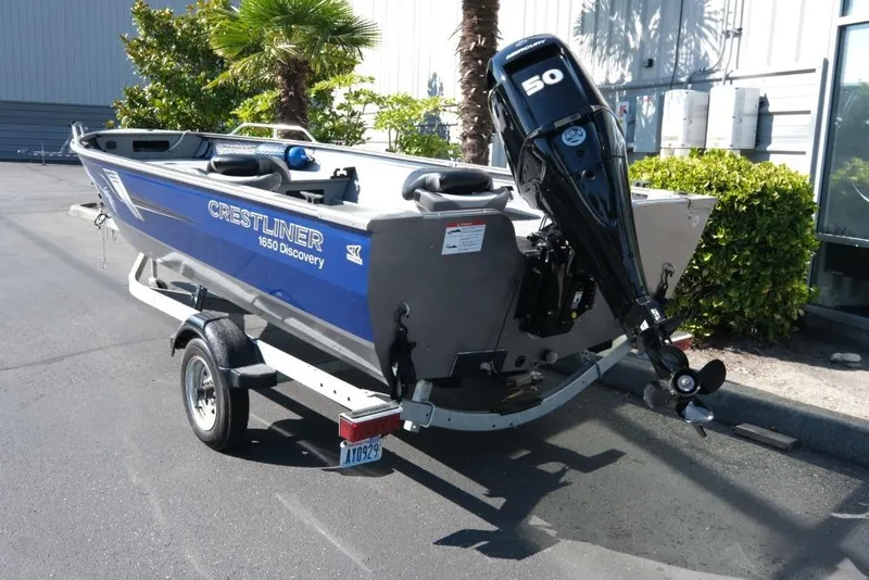 Slide: The Image of 2024 Crestliner 1650 Discovery Tiller boat on trailer, parked outdoors. - 4