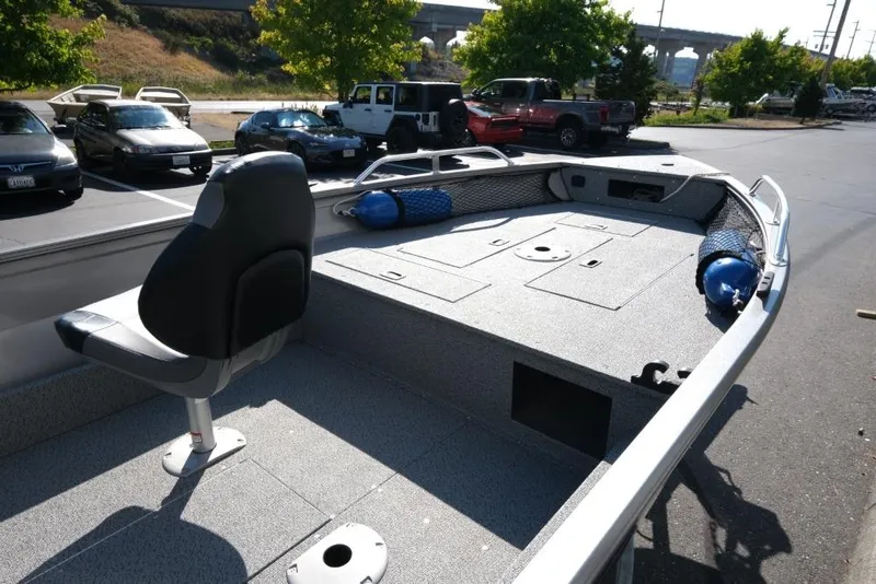 Slide: The Image of 2024 Crestliner 1650 Discovery Tiller boat with seating and storage, parked outdoors. - 9