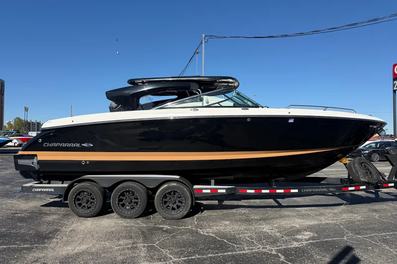 The Image of 2023 CHAPPARAL 30 Surf boat on trailer, black and white design, outdoor display. - 0