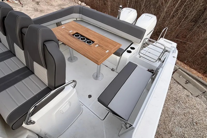 Slide: The Image of 2022 Jeanneau Leader 9.0 CC boat interior with seating and wooden table. - 11