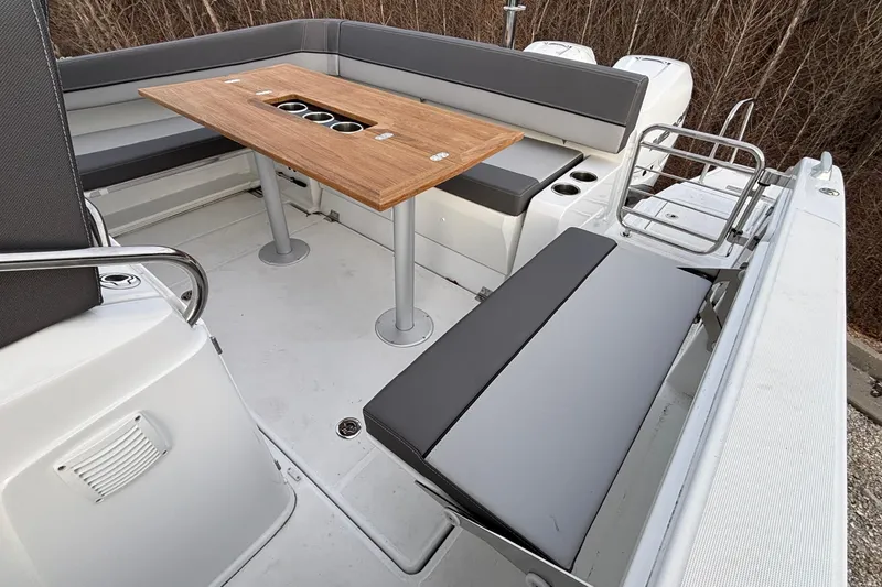 Slide: The Image of 2022 Jeanneau Leader 9.0 CC boat interior with seating and wooden table. - 12