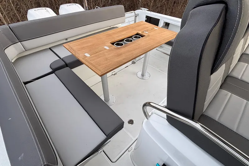 Slide: The Image of 2022 Jeanneau Leader 9.0 CC boat interior with seating and wooden table. - 14