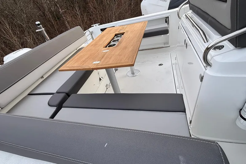 Slide: The Image of 2022 Jeanneau Leader 9.0 CC boat interior with seating and wooden table. - 15