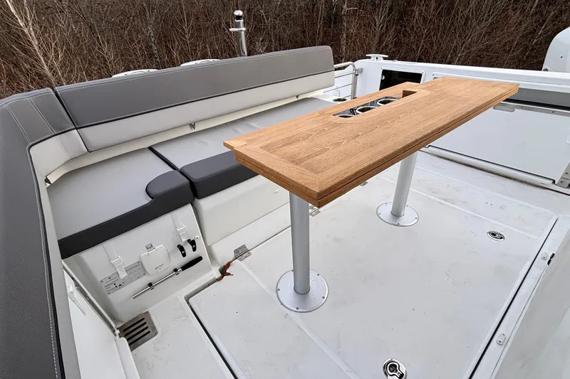 Slide: The Image of 2022 Jeanneau Leader 9.0 CC boat interior with seating and wooden table. - 3
