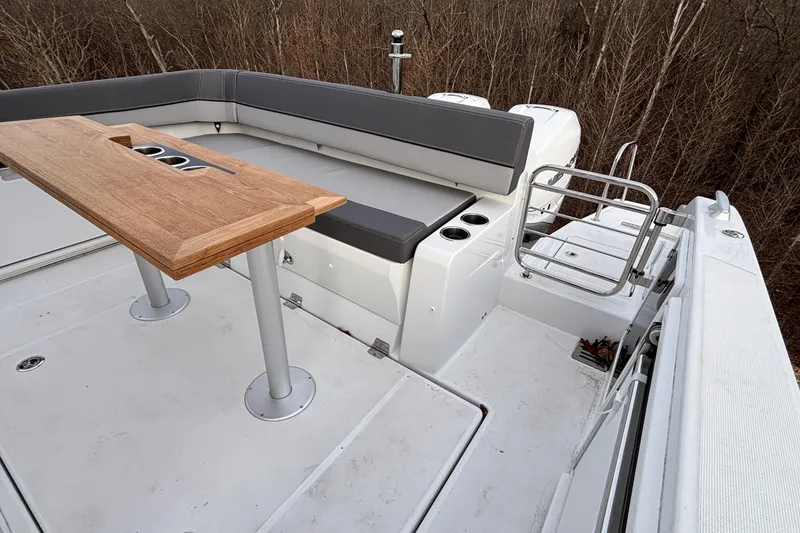 Slide: The Image of 2022 Jeanneau Leader 9.0 CC boat deck with seating and wooden table. - 6