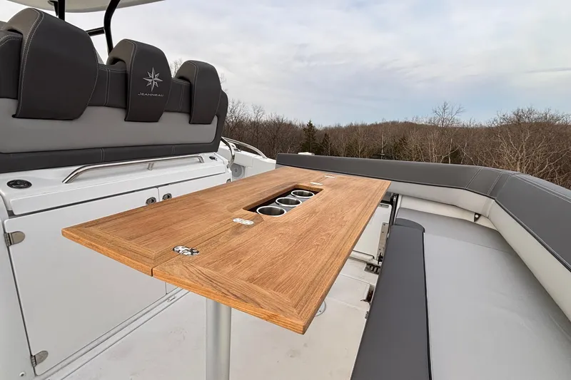 Slide: The Image of 2022 Jeanneau Leader 9.0 CC boat interior with wooden table and cushioned seating. - 8