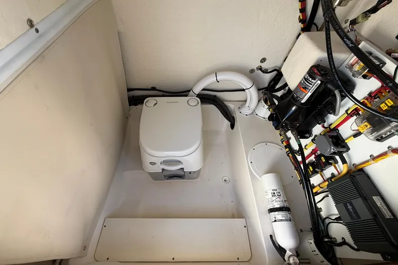 Slide: The Image of 2022 Sea Born LX24 Center Console boat interior with portable toilet and wiring. - 32