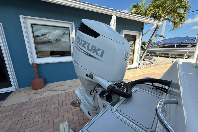 Slide: The Image of 2022 Sea Born LX24 Center Console with Suzuki outboard motor near blue building. - 9