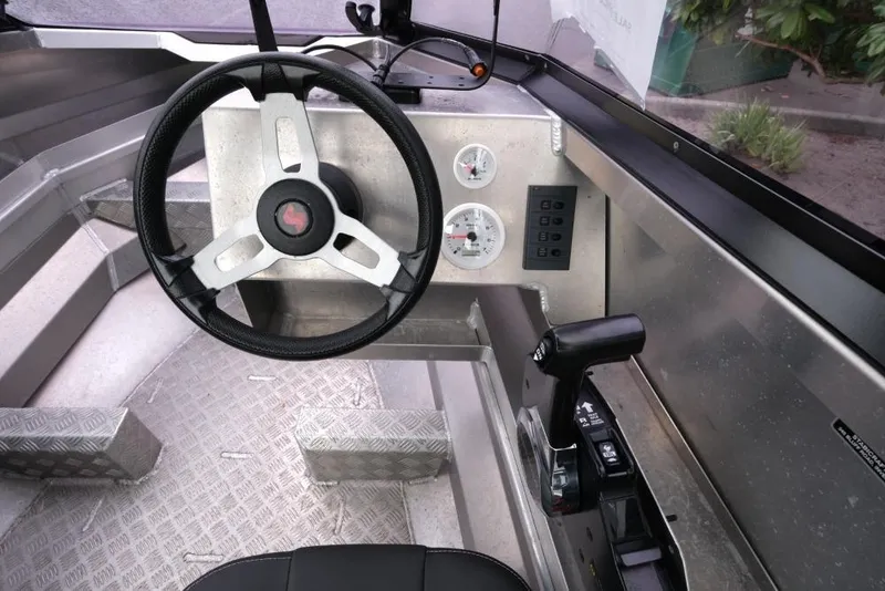 Slide: The Image of 2019 Stabicraft 1550 Fisher boat cockpit with steering wheel and control panel. - 12