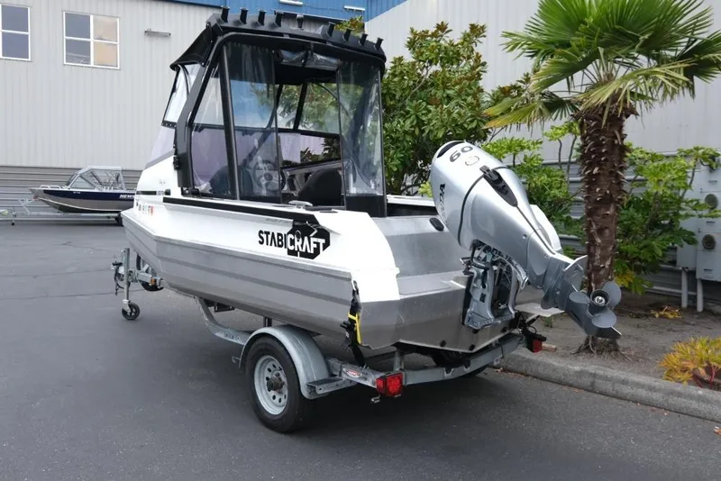 Slide: The Image of 2019 Stabicraft 1550 Fisher boat on trailer, parked outdoors near palm tree. - 4