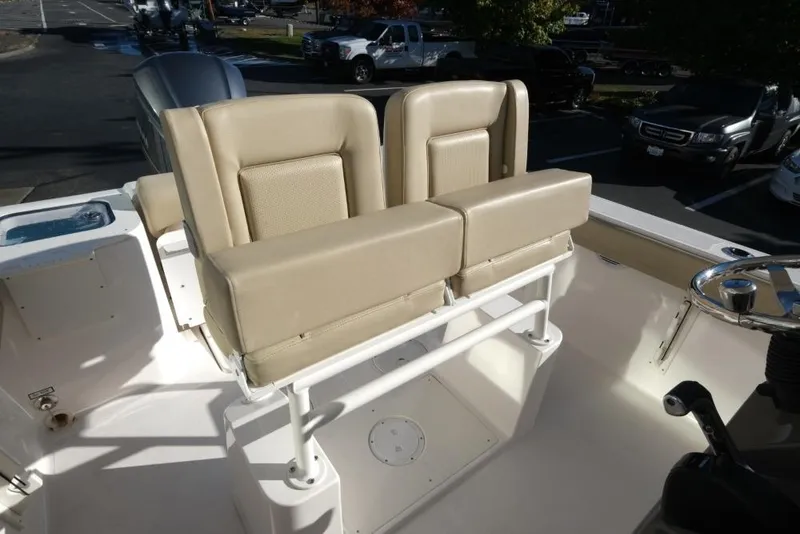 Slide: The Image of 2017 Pursuit C 238 Center Console boat with beige seating and steering wheel. - 11