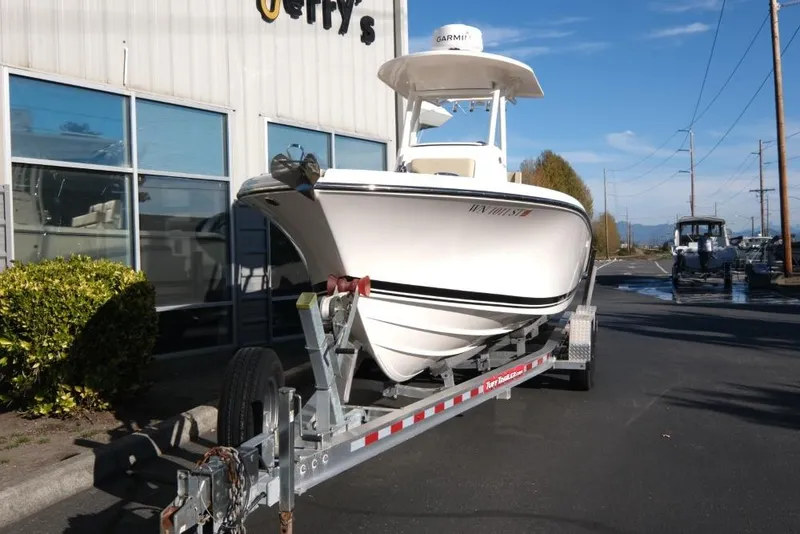 Slide: The Image of 2017 Pursuit C 238 Center Console boat on trailer outside building. - 3