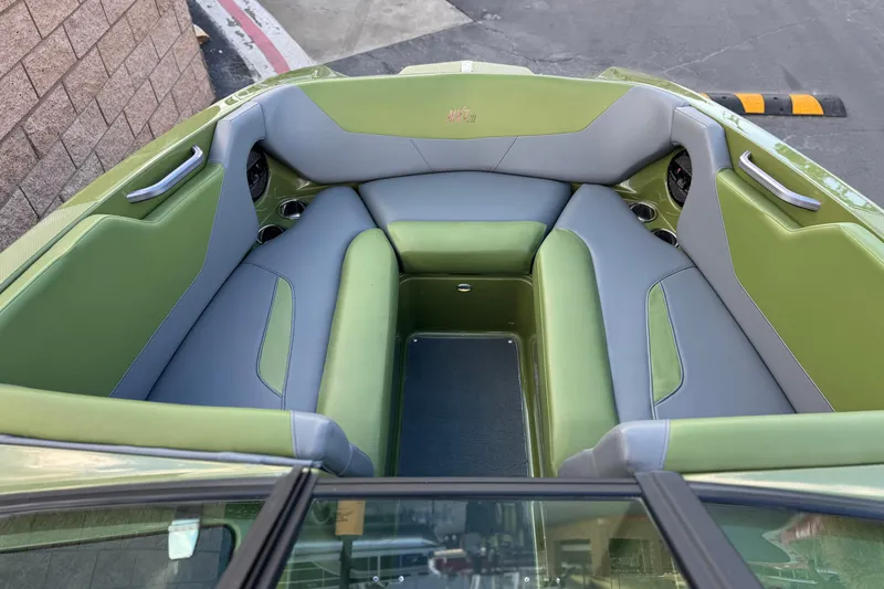 Slide: The Image of 2023 MasterCraft NXT22 boat interior with green and gray seating. - 14