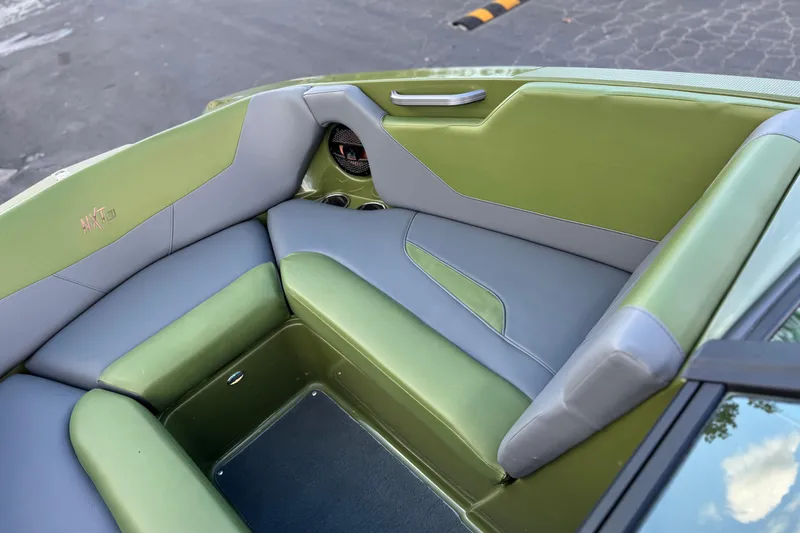 Slide: The Image of 2023 MasterCraft NXT22 boat interior with green and gray seating. - 16