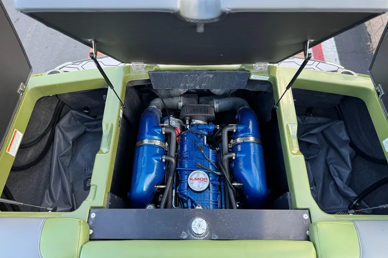 Slide: The Image of 2023 MasterCraft NXT22 engine compartment with Ilmor engine, open hatches, and storage areas. - 20