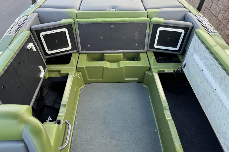 Slide: The Image of 2023 MasterCraft NXT22 boat interior with open storage compartments and green upholstery. - 23