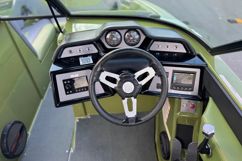 Slide: The Image of 2023 MasterCraft NXT22 boat dashboard with steering wheel and control panels. - 28
