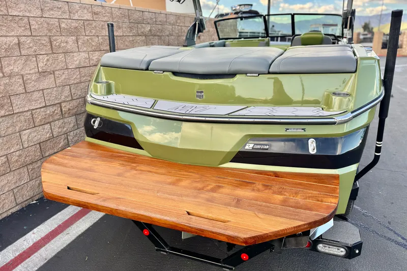 Slide: The Image of 2023 MasterCraft NXT22 boat with green exterior and wooden swim platform. - 6