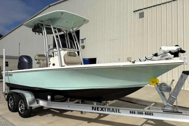 Slide: The Image of 2024 Key West 210 Bay Reef boat on Nextrail trailer, parked outside a building. - 1