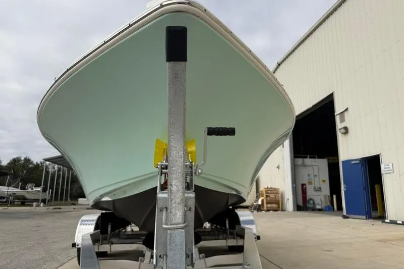 Slide: The Image of 2024 Key West 210 Bay Reef boat on trailer outside a warehouse. - 11