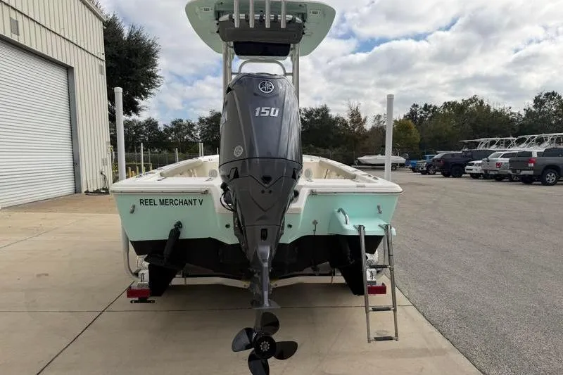 Slide: The Image of 2024 Key West 210 Bay Reef boat with Yamaha 150 engine, parked outdoors. - 15