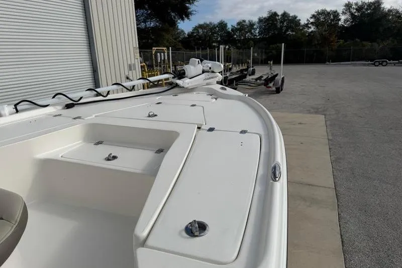 Slide: The Image of 2024 Key West 210 Bay Reef boat, white deck, parked near trailers. - 21