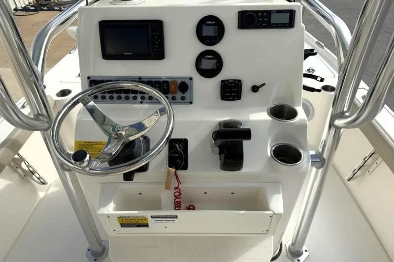 Slide: The Image of 2024 Key West 210 Bay Reef boat console with steering wheel and navigation controls. - 24