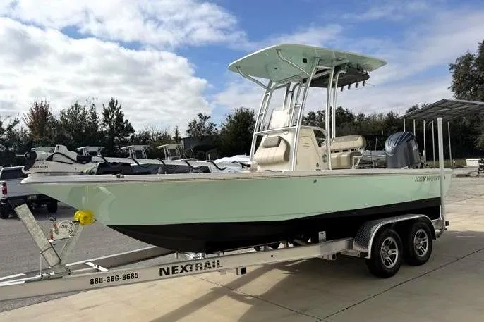 Slide: The Image of 2024 Key West 210 Bay Reef boat on trailer, parked outdoors under cloudy sky. - 3