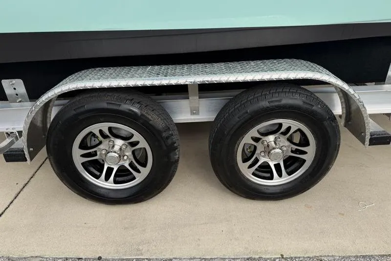 Slide: The Image of Trailer wheels of a 2024 Key West 210 Bay Reef boat on pavement. - 33