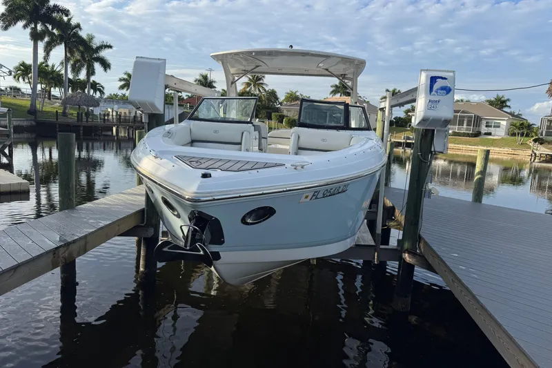 Slide: The Image of 2018 Cobalt 30SC boat docked in a scenic waterfront setting with palm trees. - 14
