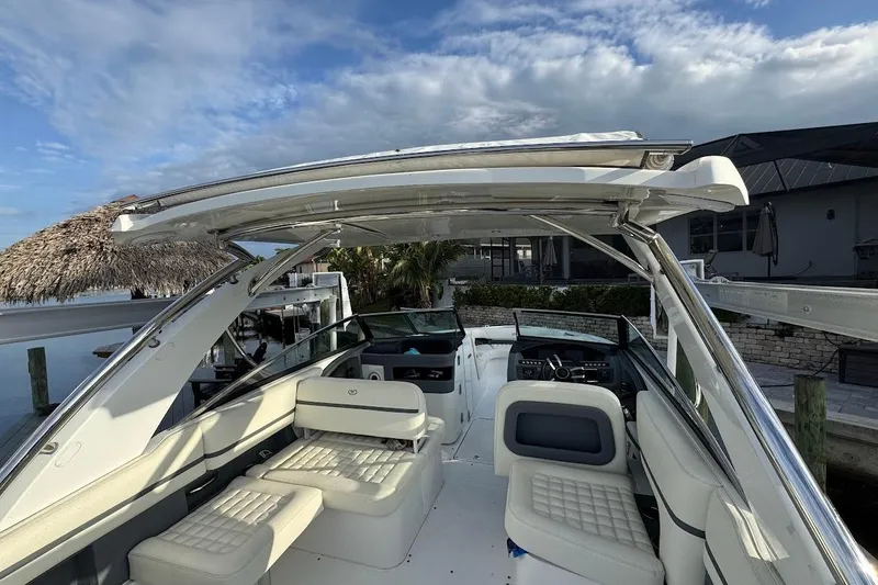 Slide: The Image of 2018 Cobalt 30SC boat interior with white seating and modern dashboard under a clear sky. - 18