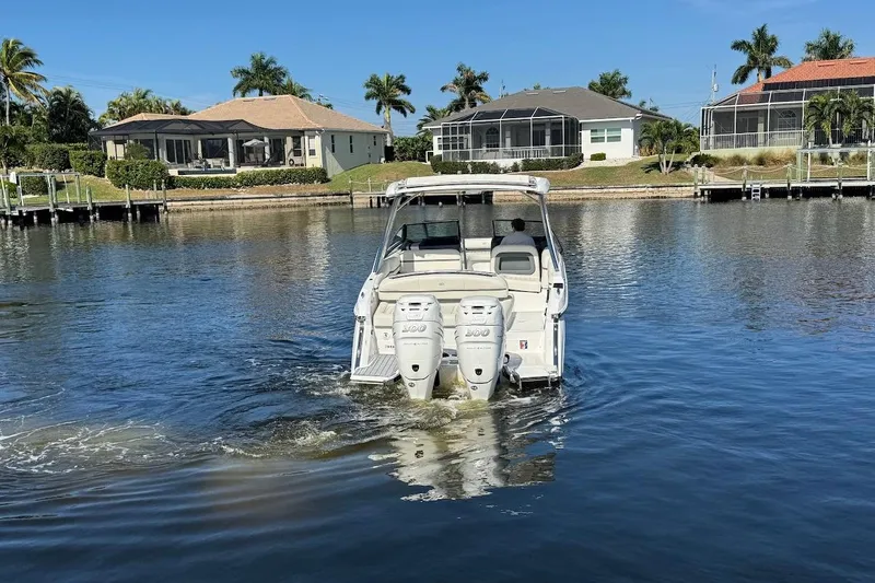 Slide: The Image of 2018 Cobalt 30SC boat cruising on a calm residential waterway. - 6