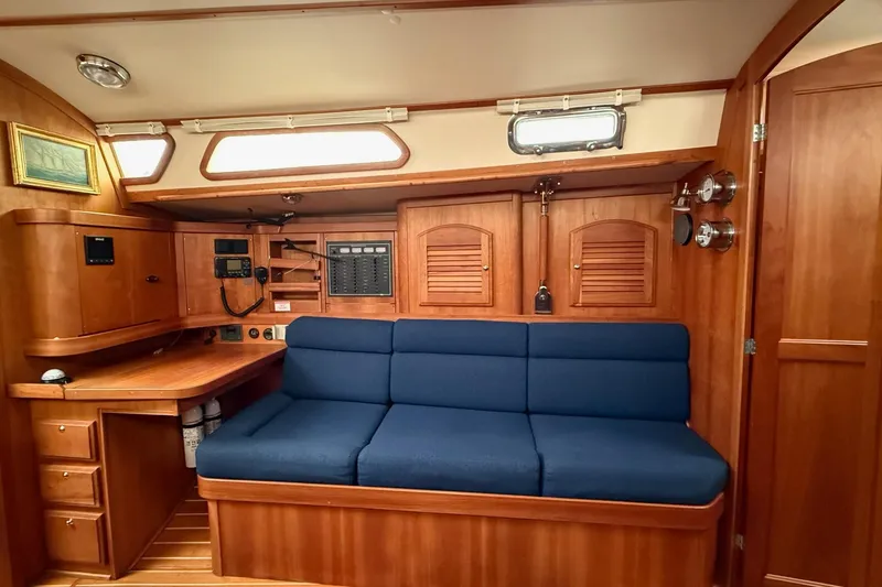 Slide: The Image of Interior of 2003 Sabre 362 sailboat with blue cushioned seating and wooden cabinetry. - 16