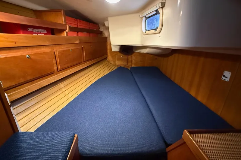 Slide: The Image of Cozy cabin interior of 2003 Sabre 362 sailboat with wooden cabinetry and blue cushions. - 24