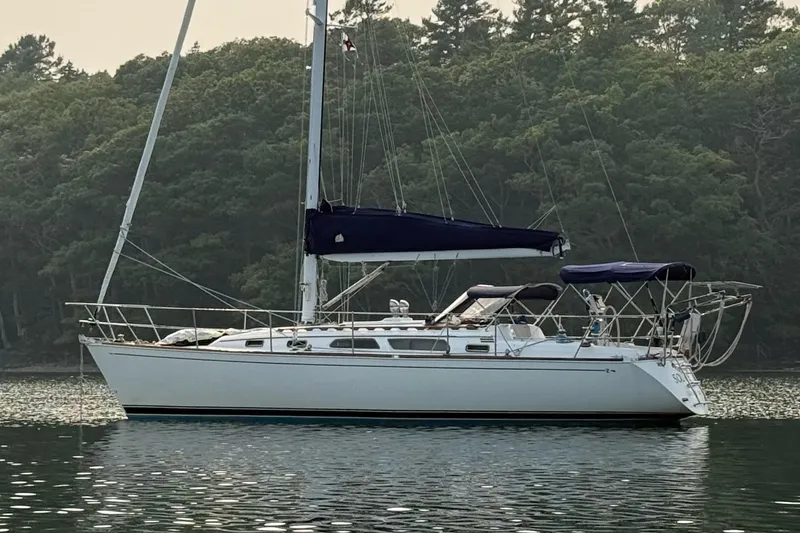 Slide: The Image of 2003 Sabre 362 sailboat anchored on calm water with forested background. - 27