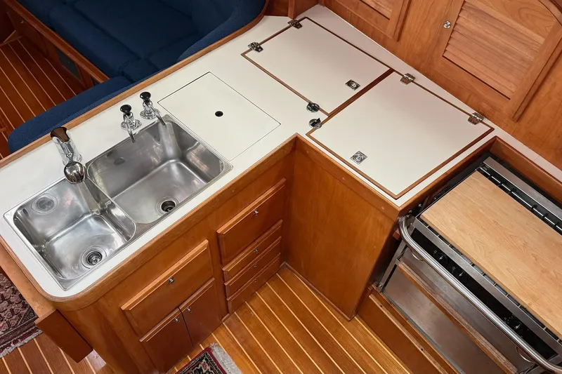 Slide: The Image of 2003 Sabre 362 yacht kitchen with double sink, wooden cabinetry, and stove. - 31