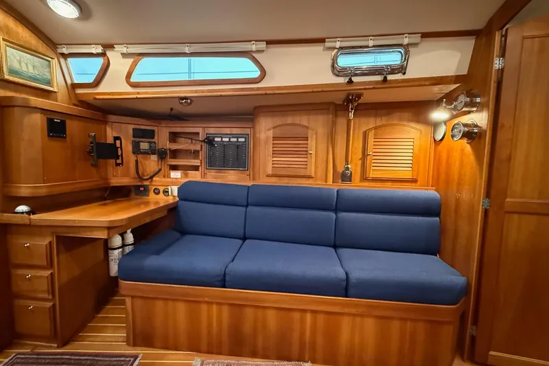 Slide: The Image of Interior of 2003 Sabre 362 yacht with blue cushioned seating and wooden cabinetry. - 9