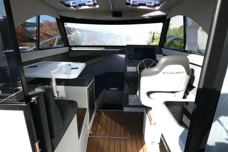 Slide: The Image of Interior of 2023 Makaira Sportfish 800 boat with seating and steering area. - 13