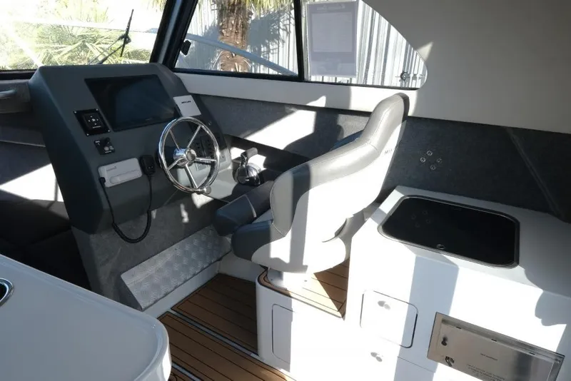 Slide: The Image of Interior of 2023 Makaira Sportfish 800 boat with steering wheel and control panel. - 15