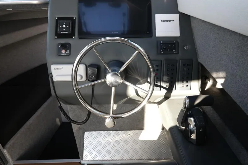 Slide: The Image of 2023 Makaira Sportfish 800 boat dashboard with steering wheel and control panel. - 17
