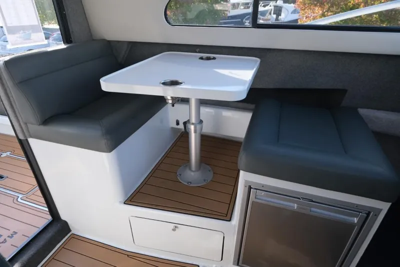 Slide: The Image of Interior of 2023 Makaira Sportfish 800, featuring a compact dining area with cushioned seating. - 19