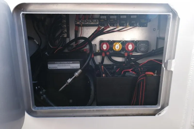 Slide: The Image of Electrical compartment of 2023 Makaira Sportfish 800 boat, showing wiring and power steering pump. - 25