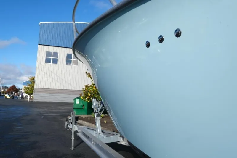 Slide: The Image of 2023 Makaira Sportfish 800 boat on trailer near industrial building. - 4