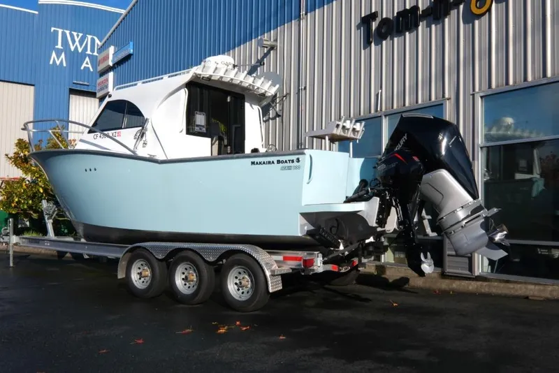 Slide: The Image of 2023 Makaira Sportfish 800 boat on trailer outside a marine dealership. - 5