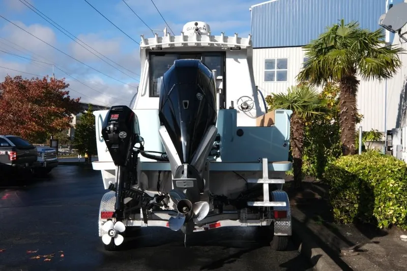 Slide: The Image of 2023 Makaira Sportfish 800 boat with dual outboard motors, parked outdoors. - 7